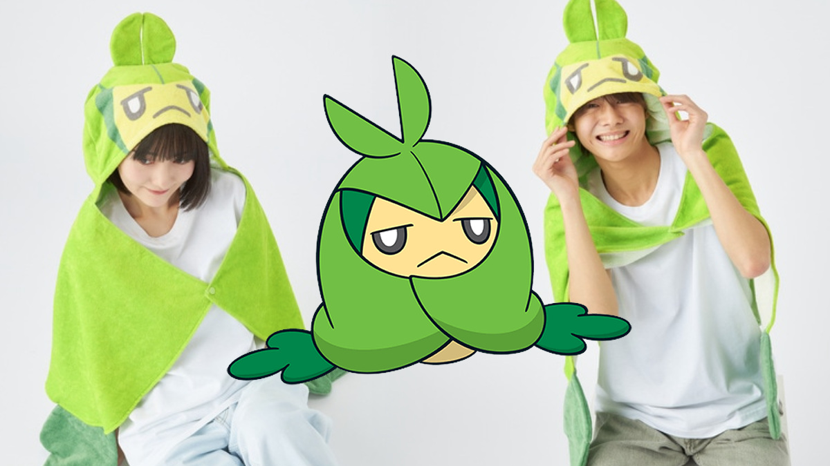 An image of two adults wearing a hood shaped like Swadloon, with an illustration of Swadloon between them.